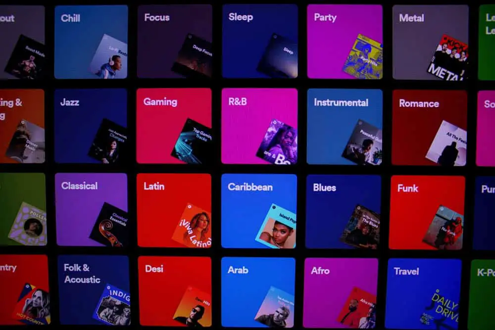 A vibrant grid display showcases various music genres on a screen. Displayed are colorful squares featuring album art and text for each genre, including Jazz, Gaming, R&B, Instrumental, and more. This visually rich setup reflects the diversity and variety of music categories available.